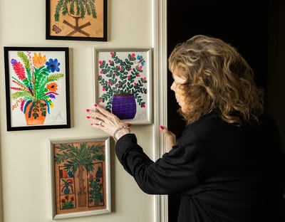 Resident admiring artwork in a hallway of the facility
