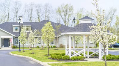 Exterior view of the facility with blooming trees and gazebo