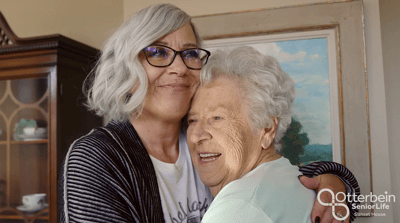 Two women embracing in a warm indoor setting