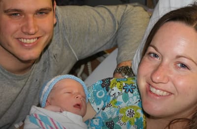 New parents smiling with their newborn baby
