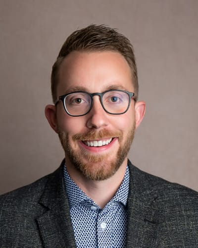 Smiling man wearing glasses and a blazer
