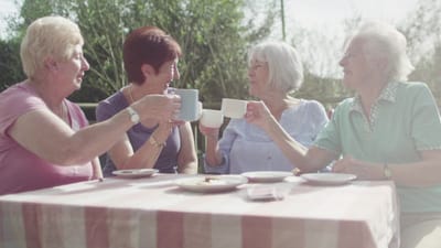Residents enjoying tea outside on a sunny day