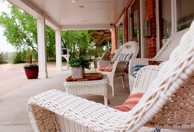 Outdoor seating area with wicker chairs and greenery