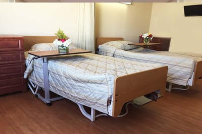 Private resident room with two beds and flowers