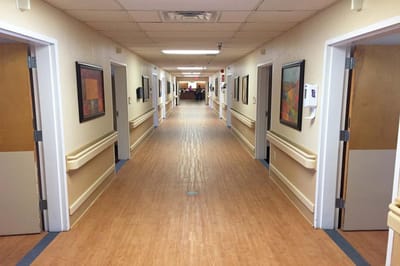 A well-lit hallway with several doors and artwork