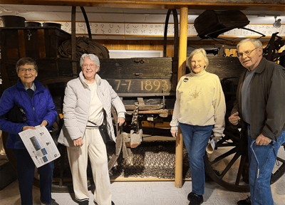 Residents posing in front of vintage wagon display