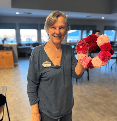 Resident holding a handmade wreath in a common area
