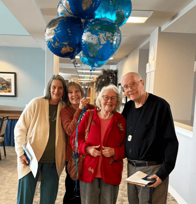 Four residents celebrating with balloons in a common area