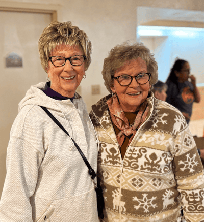 Two residents smiling together in a cozy interior space