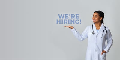 A nurse holding out a hand with a hiring sign