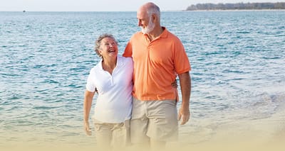 Couple walking by the beach, smiling and enjoying