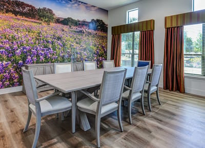 Brightly lit common area with a floral mural