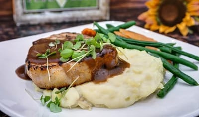 A plate of mashed potatoes, green beans, and chicken