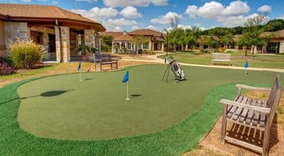 Outdoor putting green with benches and landscaping