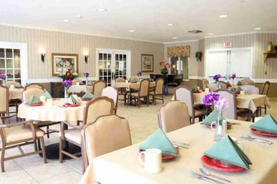Dining room set for a meal with flowers on the tables