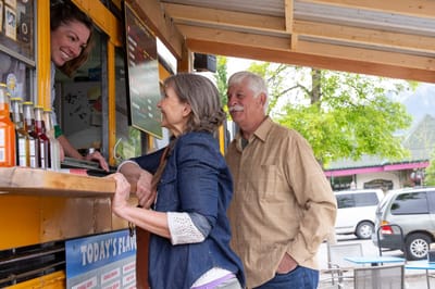 People interacting at a food truck outdoors