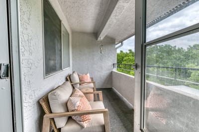 Seating area on a balcony overlooking greenery