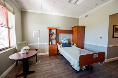 A private resident room with a bed and chair