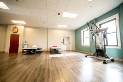 A well-lit physical therapy gym with exercise equipment
