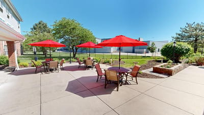 Outdoor patio area with red umbrellas and seating