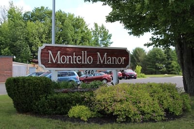 Signage for Montello Manor with surrounding greenery