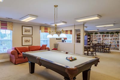 Common area with a pool table and bookshelves