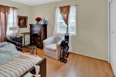 Cozy resident room with a bed and wheelchair