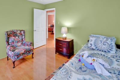 Cozy resident room with floral chair and bedding
