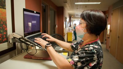 Staff member using a computer in a facility hallway