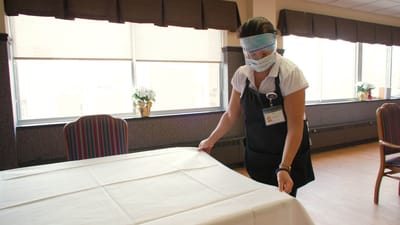 Staff member setting a table in a dining area