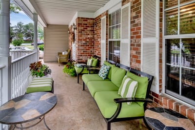 Outdoor seating area with green couches and plants