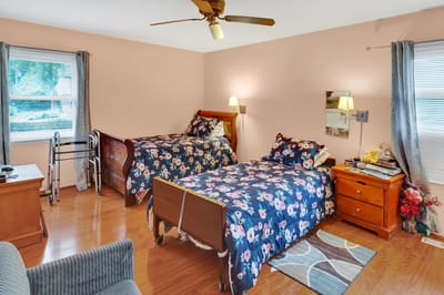 A cozy resident room with twin beds and bedside tables