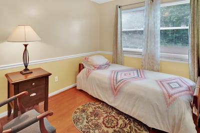 A private resident room with a bed and lamp