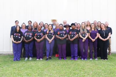 Staff members posing in front of a facility
