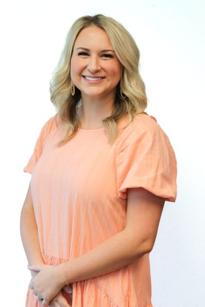 Smiling staff member in an orange dress