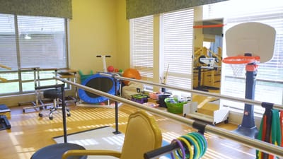 A bright activity room with therapy equipment