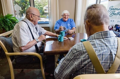 Three residents playing cards at a table