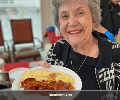 Resident enjoying a meal with a smile
