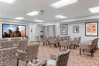 Interior of a common area with seating and a screen