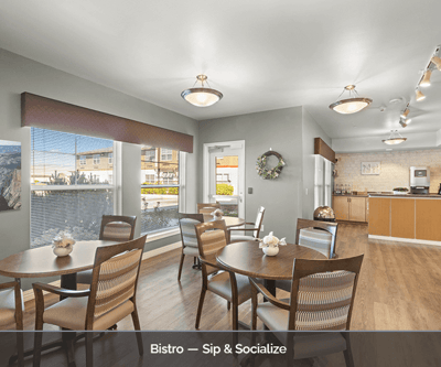 Bright dining area with round tables and a kitchenette