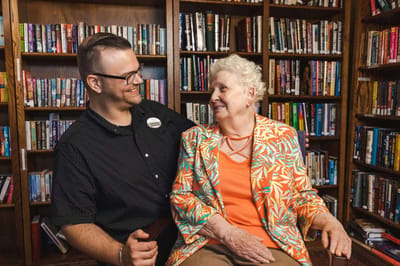 Volunteers interacting warmly with a resident in the library