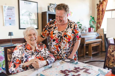 A staff member interacting with a smiling resident in a common area