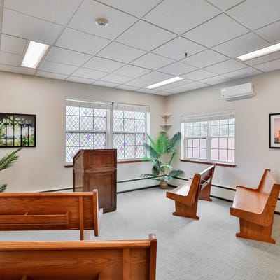 Interior chapel space with wooden seating and plants