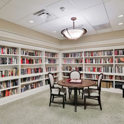 Bright interior library with bookshelves and a table