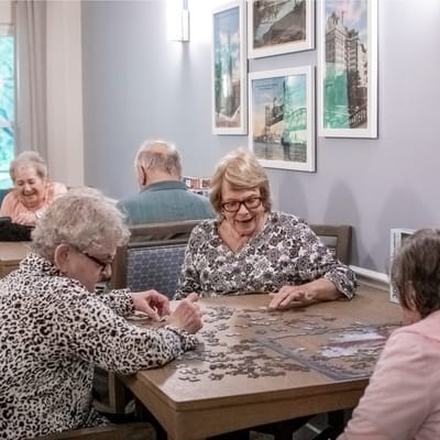 Residents enjoying a puzzle activity in a common area