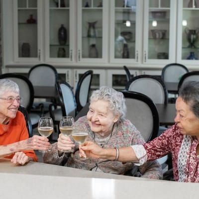 Residents toasting with drinks in a common area