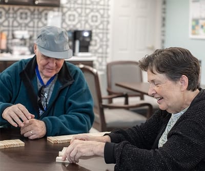 Residents engaging in a game at a common area table