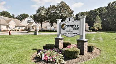 Sign for Peregrine Senior Living at Clifton Park with landscaped flower bed