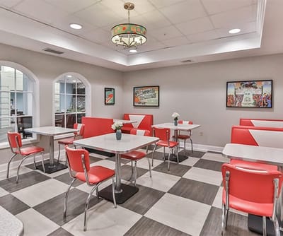 Bright dining area with red chairs and tables