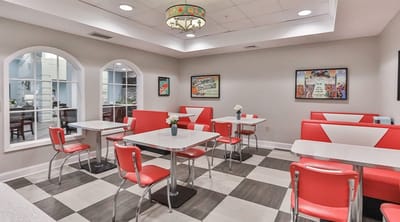 Bright dining area with red chairs and tables